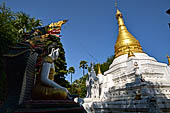 Myanmar - Inwa, white washed stupas with a Buddha statue protected by a naga where the road branch off to the teack monastery. 